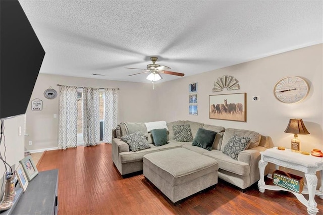 living room with a textured ceiling, hardwood / wood-style flooring, and ceiling fan