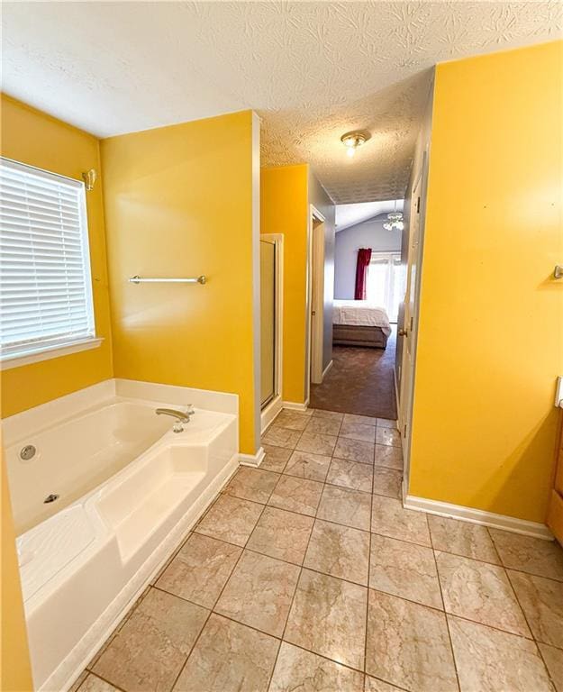 bathroom with vaulted ceiling, shower with separate bathtub, vanity, tile patterned floors, and a textured ceiling