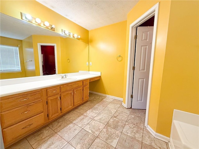 bathroom with vanity, a bath, and a textured ceiling