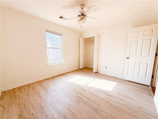 unfurnished bedroom with light hardwood / wood-style floors, a closet, and ceiling fan