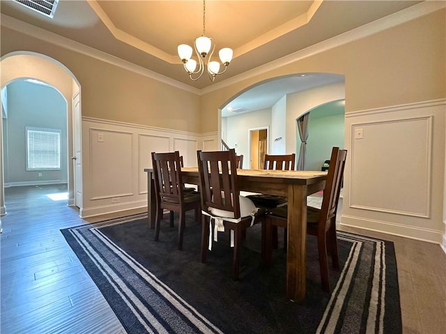 360 Walker Rd, Byron, GA 31008 - dining space with a decorative wall, a chandelier, arched walkways, a tray ceiling, and wainscoting