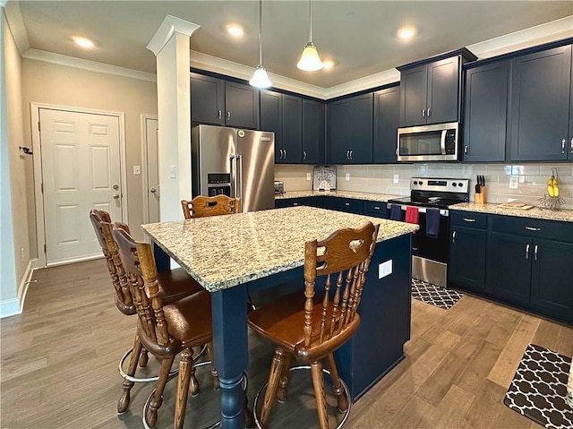 360 Walker Rd, Byron, GA 31008 - kitchen featuring appliances with stainless steel finishes, ornamental molding, a breakfast bar, light stone counters, and a kitchen island