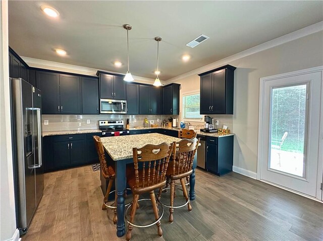 360 Walker Rd, Byron, GA 31008 - kitchen with appliances with stainless steel finishes, ornamental molding, a center island, tasteful backsplash, and light stone counters