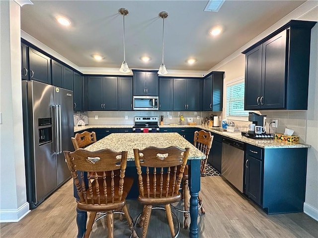 360 Walker Rd, Byron, GA 31008 - kitchen with appliances with stainless steel finishes, light wood-style flooring, light stone counters, a breakfast bar area, and decorative backsplash
