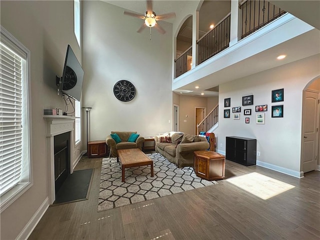 360 Walker Rd, Byron, GA 31008 - living room with a glass covered fireplace, stairway, wood finished floors, ceiling fan, and a high ceiling