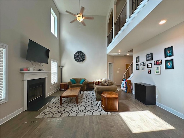 360 Walker Rd, Byron, GA 31008 - living room with ceiling fan, a fireplace with raised hearth, plenty of natural light, wood finished floors, and a high ceiling