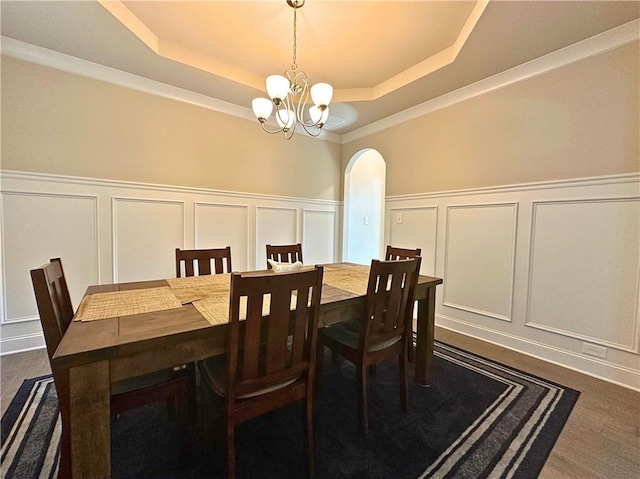 360 Walker Rd, Byron, GA 31008 - dining room with a decorative wall, a tray ceiling, arched walkways, a wainscoted wall, and a chandelier