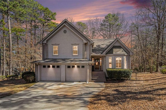 view of front of property featuring driveway, an attached garage, and stucco siding