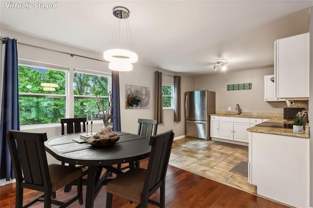 dining space featuring a wealth of natural light, sink, and wood-type flooring