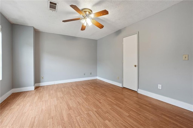 empty room featuring ceiling fan, a textured ceiling, and light wood-type flooring