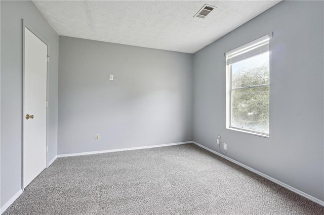 unfurnished room featuring carpet floors and a textured ceiling