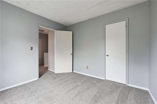 unfurnished bedroom featuring a textured ceiling and light carpet