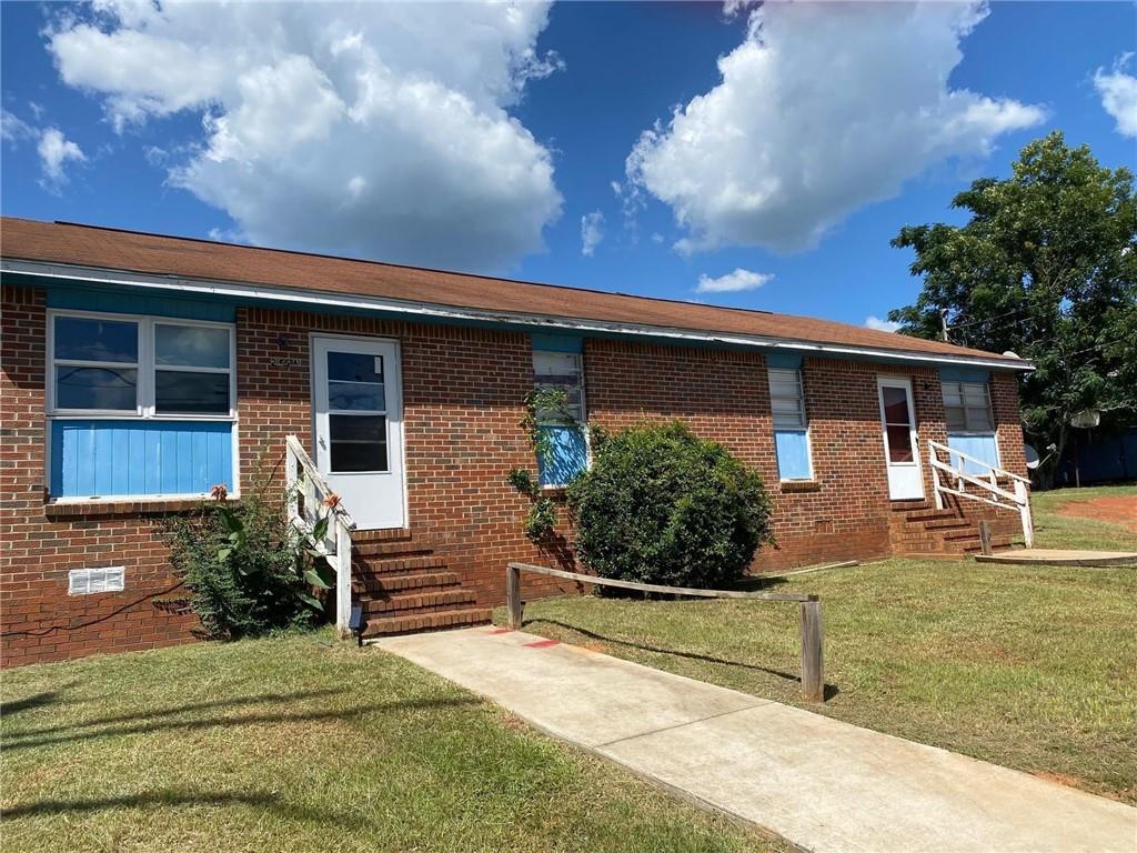 245 Horton Dr, Americus, GA 31719 - ranch-style house with entry steps, brick siding, and a front yard