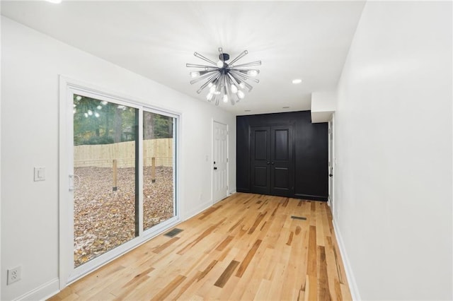 entryway featuring an inviting chandelier and light hardwood / wood-style floors