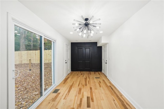 kitchen featuring light hardwood / wood-style floors, a towering ceiling, sink, backsplash, and appliances with stainless steel finishes