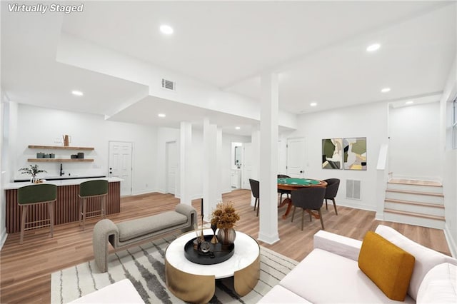 bar with sink and light hardwood / wood-style floors