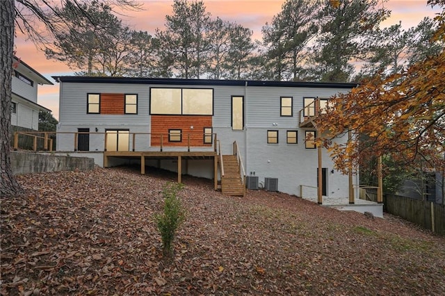 back of house featuring central air condition unit and a wooden deck