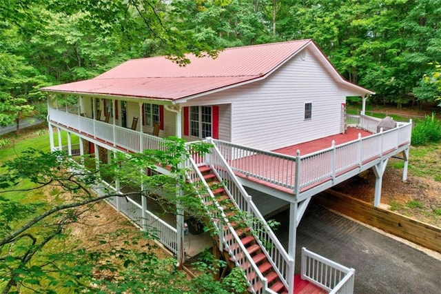 view of front of house featuring a deck, metal roof, and stairway