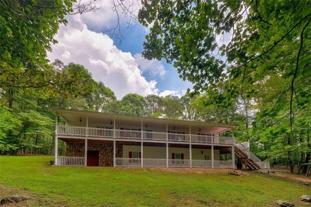 rear view of house with a deck, a yard, and stairway