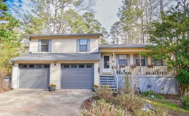 tri-level home featuring covered porch, driveway, an attached garage, and stairs