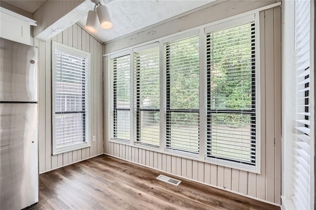 unfurnished dining area featuring a wealth of natural light, lofted ceiling, ceiling fan, and dark wood-type flooring