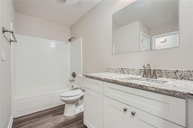 full bathroom with vanity, a textured ceiling, wood-type flooring, toilet, and  shower combination