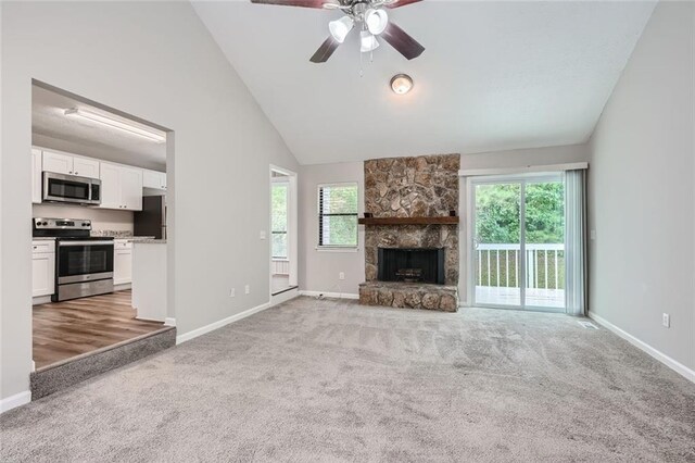 unfurnished living room with a wealth of natural light, carpet, ceiling fan, and a fireplace