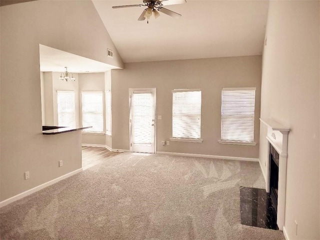 unfurnished living room with light carpet, lofted ceiling, and ceiling fan with notable chandelier