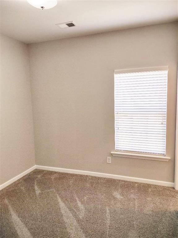 empty room featuring carpet flooring and plenty of natural light