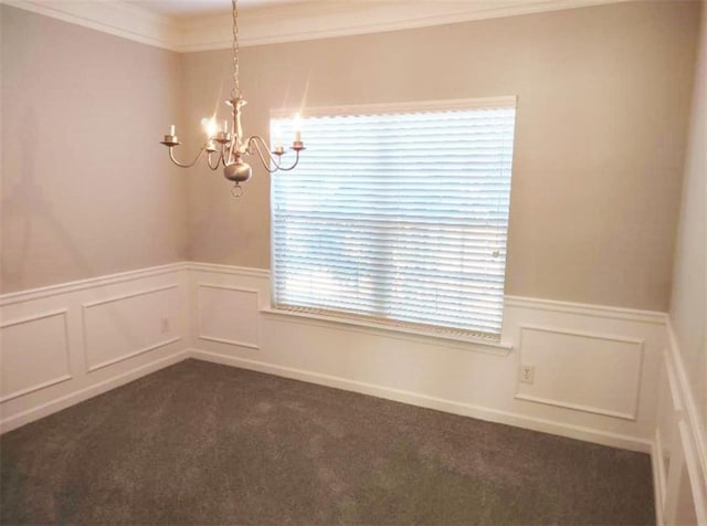 unfurnished room featuring a chandelier, crown molding, and dark colored carpet