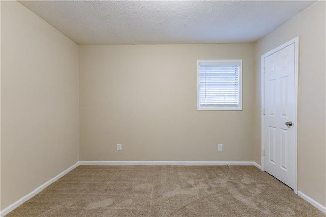 carpeted spare room with a textured ceiling