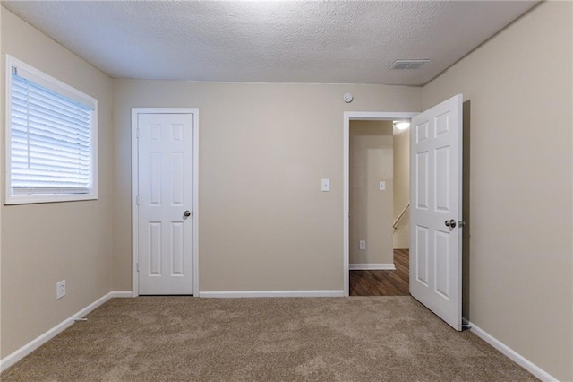 unfurnished bedroom with carpet floors and a textured ceiling