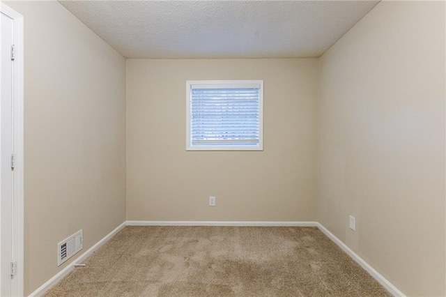 carpeted spare room with a textured ceiling