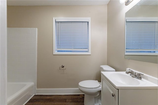 full bathroom with washtub / shower combination, vanity, wood-type flooring, and toilet