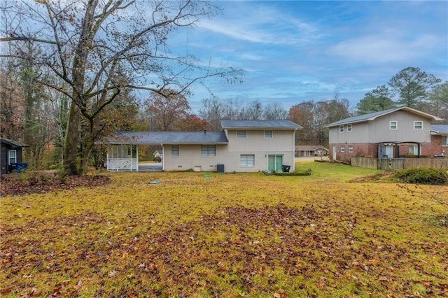 back of property featuring cooling unit and a lawn
