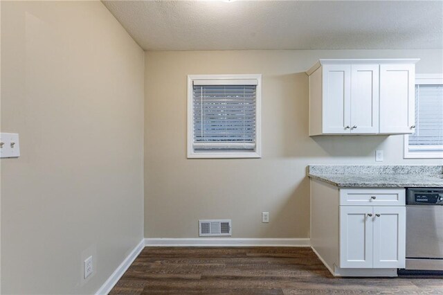 laundry room with a textured ceiling and dark wood-type flooring