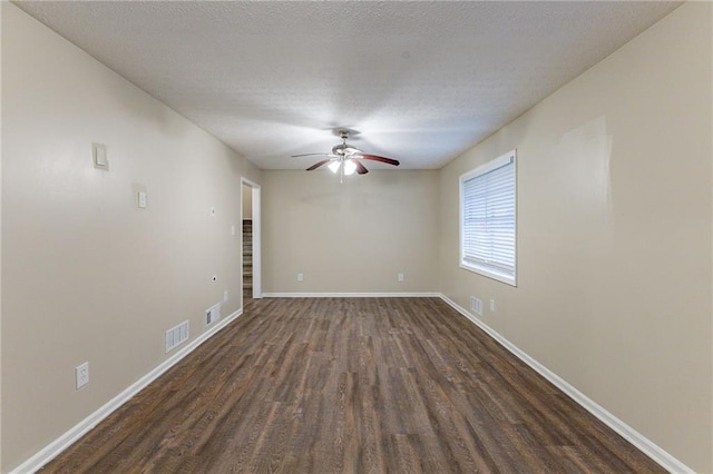 spare room featuring dark hardwood / wood-style floors, ceiling fan, and a textured ceiling