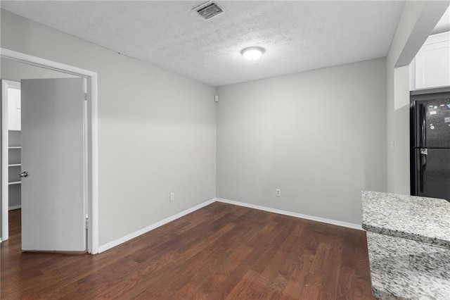 603 Summit N Dr NE Unit 603, Atlanta, GA 30324 - unfurnished dining area featuring dark wood-style flooring, baseboards, and a textured ceiling