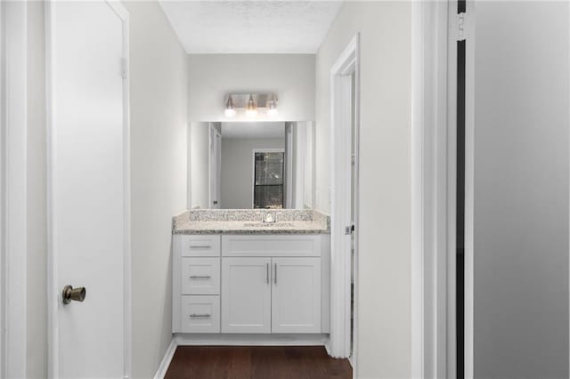 603 Summit N Dr NE Unit 603, Atlanta, GA 30324 - bathroom featuring vanity, wood finished floors, a textured ceiling, and baseboards