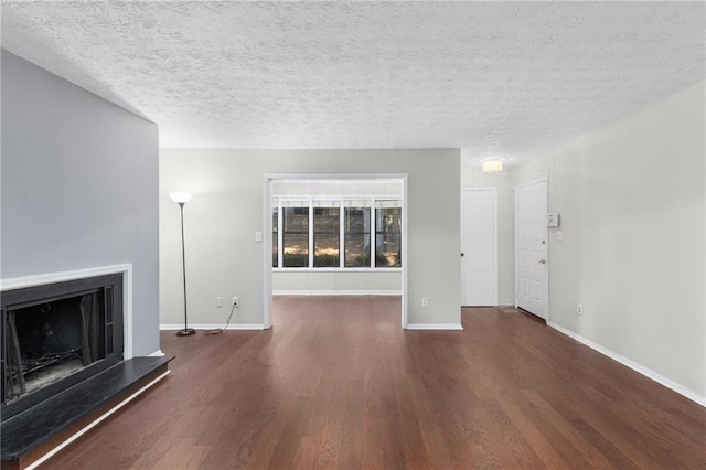 603 Summit N Dr NE Unit 603, Atlanta, GA 30324 - unfurnished living room featuring wood finished floors, a fireplace with raised hearth, baseboards, and a textured ceiling