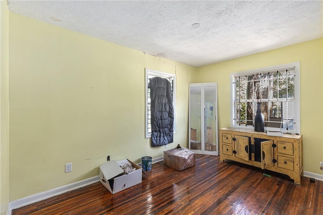 miscellaneous room with a textured ceiling and dark hardwood / wood-style flooring