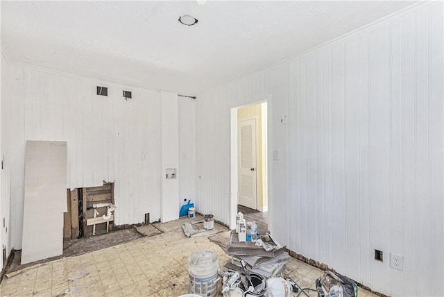 unfurnished living room featuring wood walls