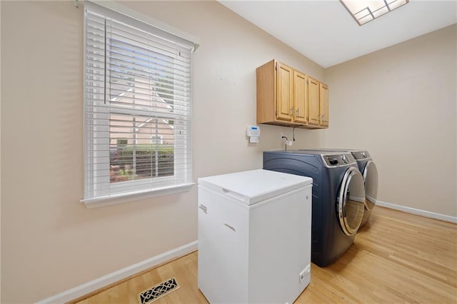 5711 Brynwood Cir NW, Acworth, GA 30101 - laundry area featuring washing machine and clothes dryer, cabinet space, baseboards, and light wood-style flooring