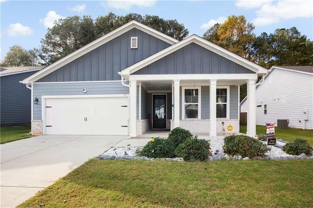 view of front of house featuring a garage, covered porch, concrete driveway, board and batten siding, and a front yard