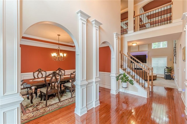 3202 Lucky Pl, Conyers, GA 30013 - foyer entrance featuring light wood-style floors, a high ceiling, stairway, a wainscoted wall, and arched walkways