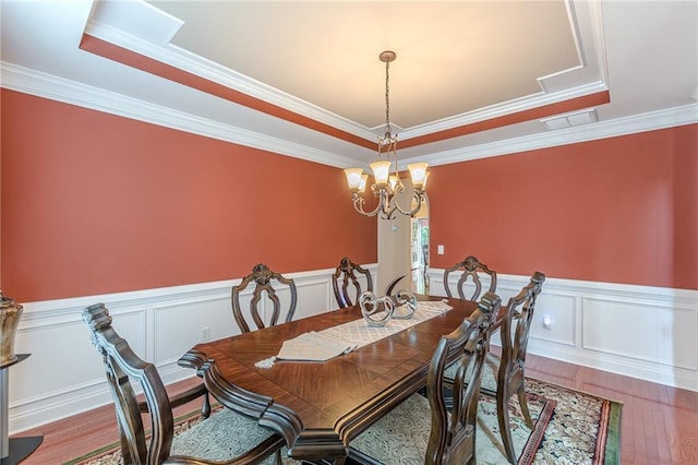 3202 Lucky Pl, Conyers, GA 30013 - dining area featuring wood finished floors, ornamental molding, wainscoting, a raised ceiling, and a chandelier