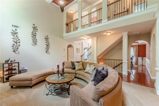 3202 Lucky Pl, Conyers, GA 30013 - living room featuring arched walkways, a towering ceiling, carpet, healthy amount of natural light, and wood finished floors