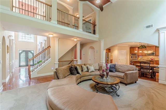 3202 Lucky Pl, Conyers, GA 30013 - living room featuring a high ceiling, arched walkways, light wood-style flooring, and stairs