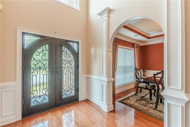 3202 Lucky Pl, Conyers, GA 30013 - foyer with french doors, arched walkways, light wood-type flooring, crown molding, and a wainscoted wall