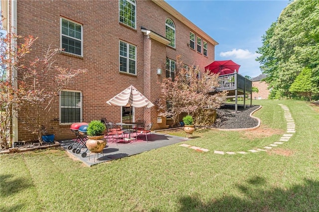 3202 Lucky Pl, Conyers, GA 30013 - rear view of property featuring brick siding, a lawn, a patio, and a wooden deck